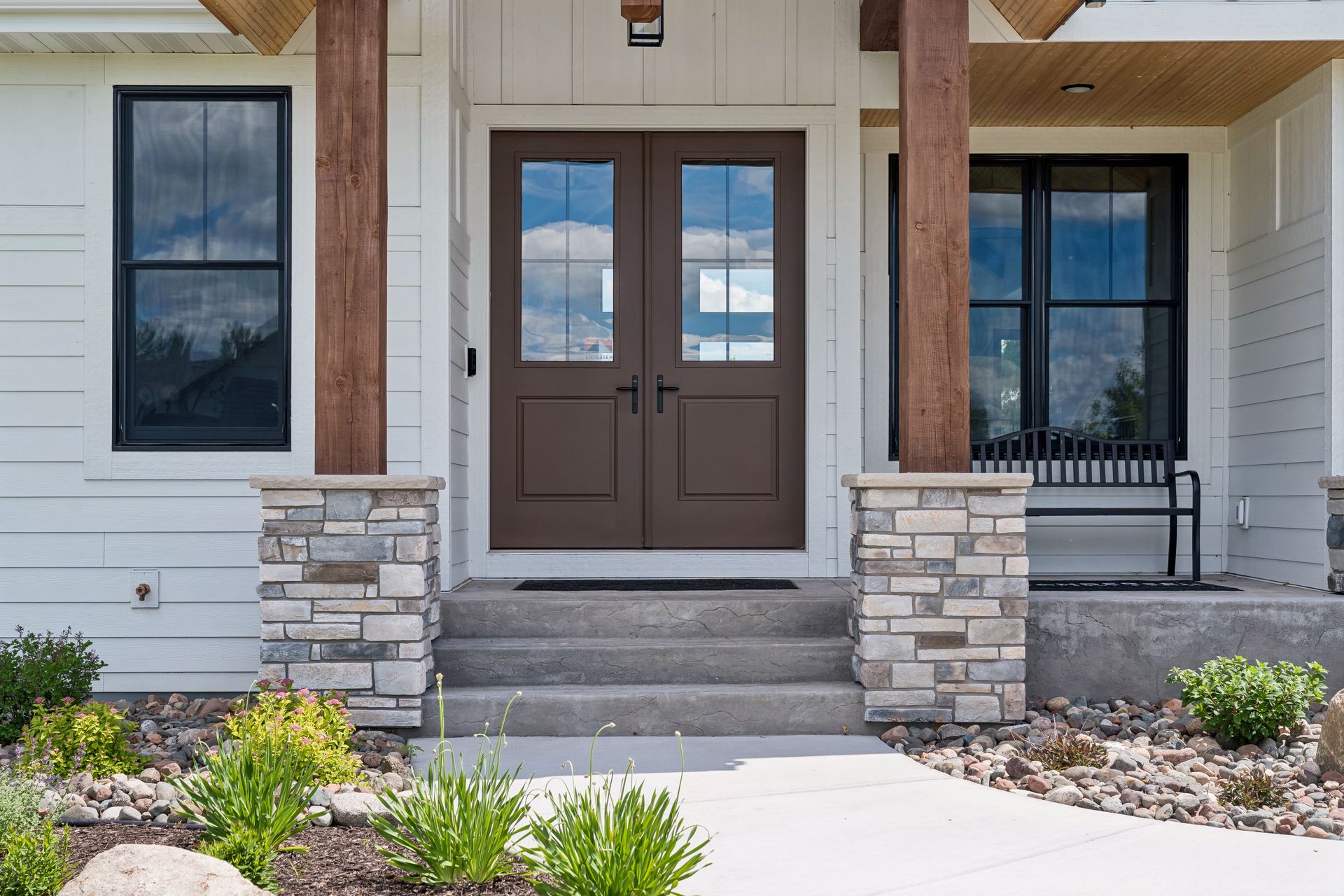 Covered front porch with timber accents and double entry doors